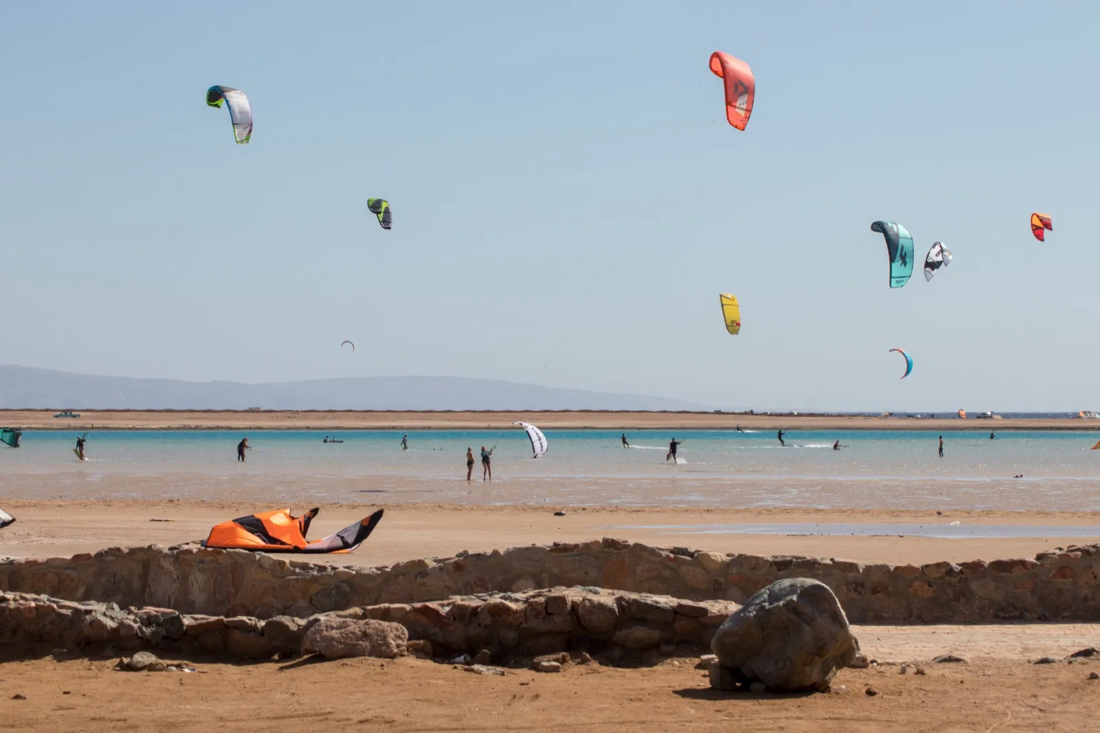 Multiple kites flying over Dahab Lagoon with the Sinai mountains in the background