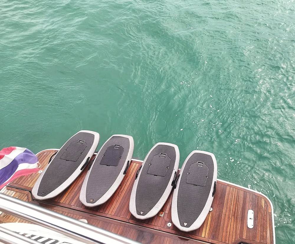 Four e-foil boards on the wooden deck of a boat