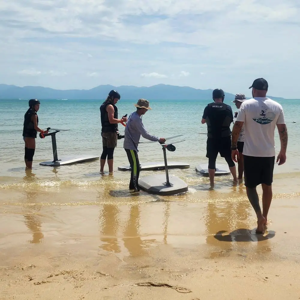 Efoil Samui instructors and guests with e-foil boards in knee-deep water at Bangrak Beach