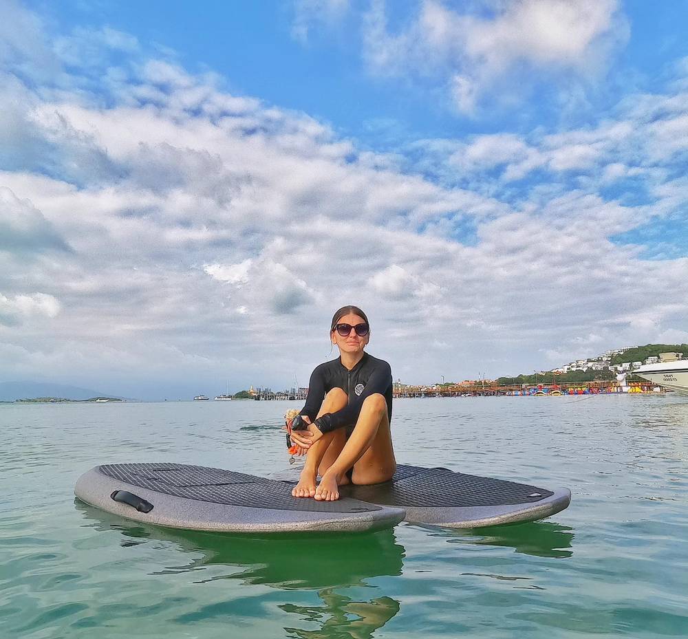 Guest sitting on her board on the calm water