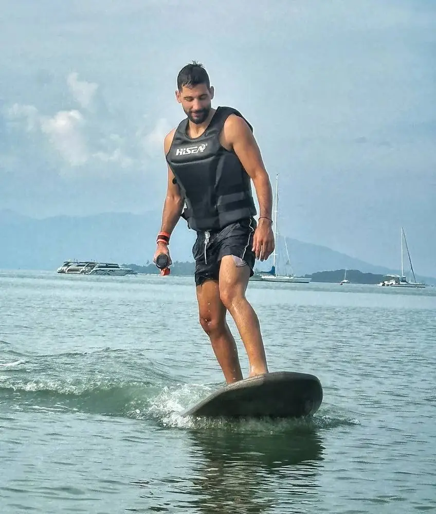 A jetsurf rider in a life vest standing on the board