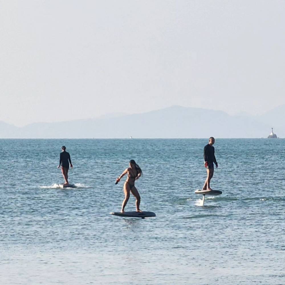 Three riders on their e-foils together in the bay