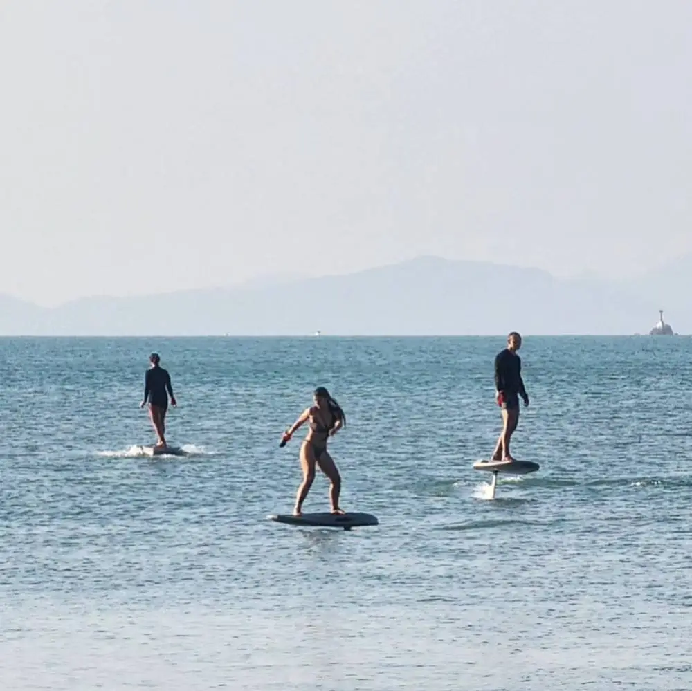 Three riders on their e-foils together in the bay of Bangrak Beach