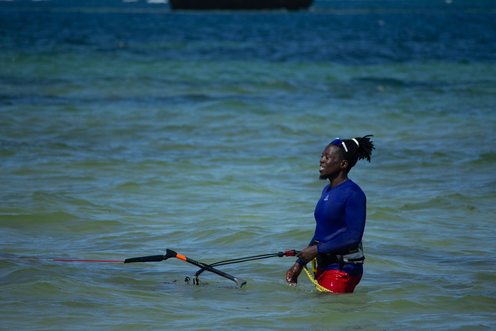 Student standing in the water holding the control bar out to the side