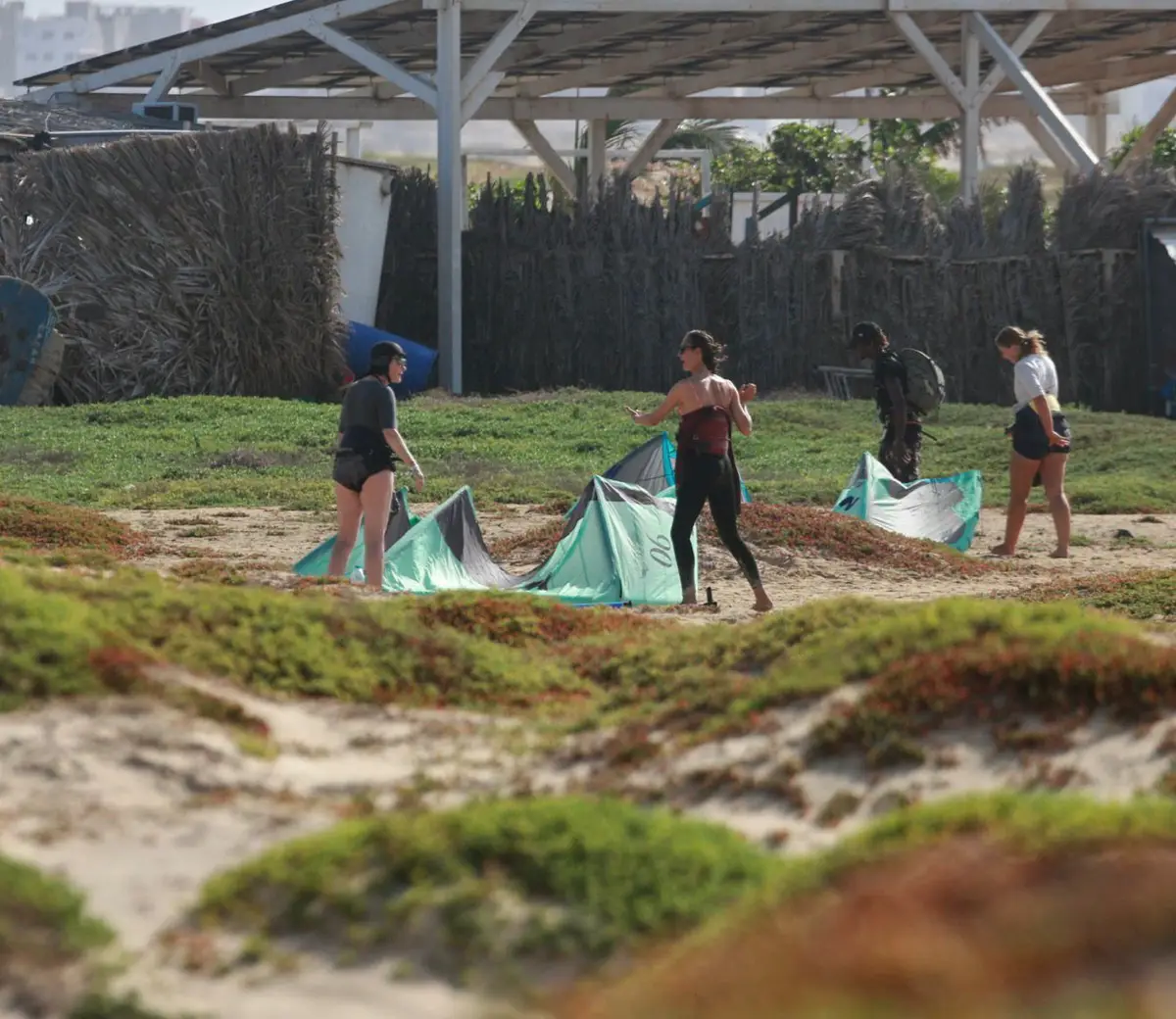 Students practising with small kites in the dunes behind the beach centre