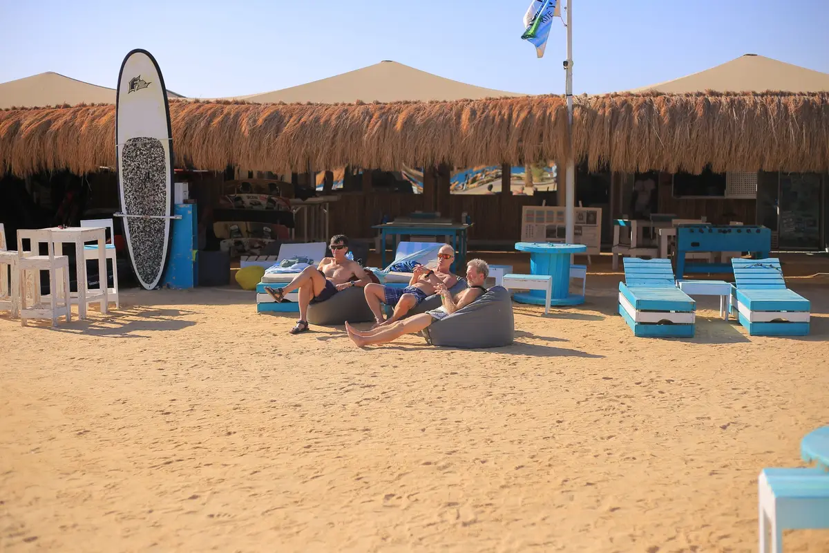 The thatched beach base at Safaga with guests relaxing on bean bags and loungers on the sand