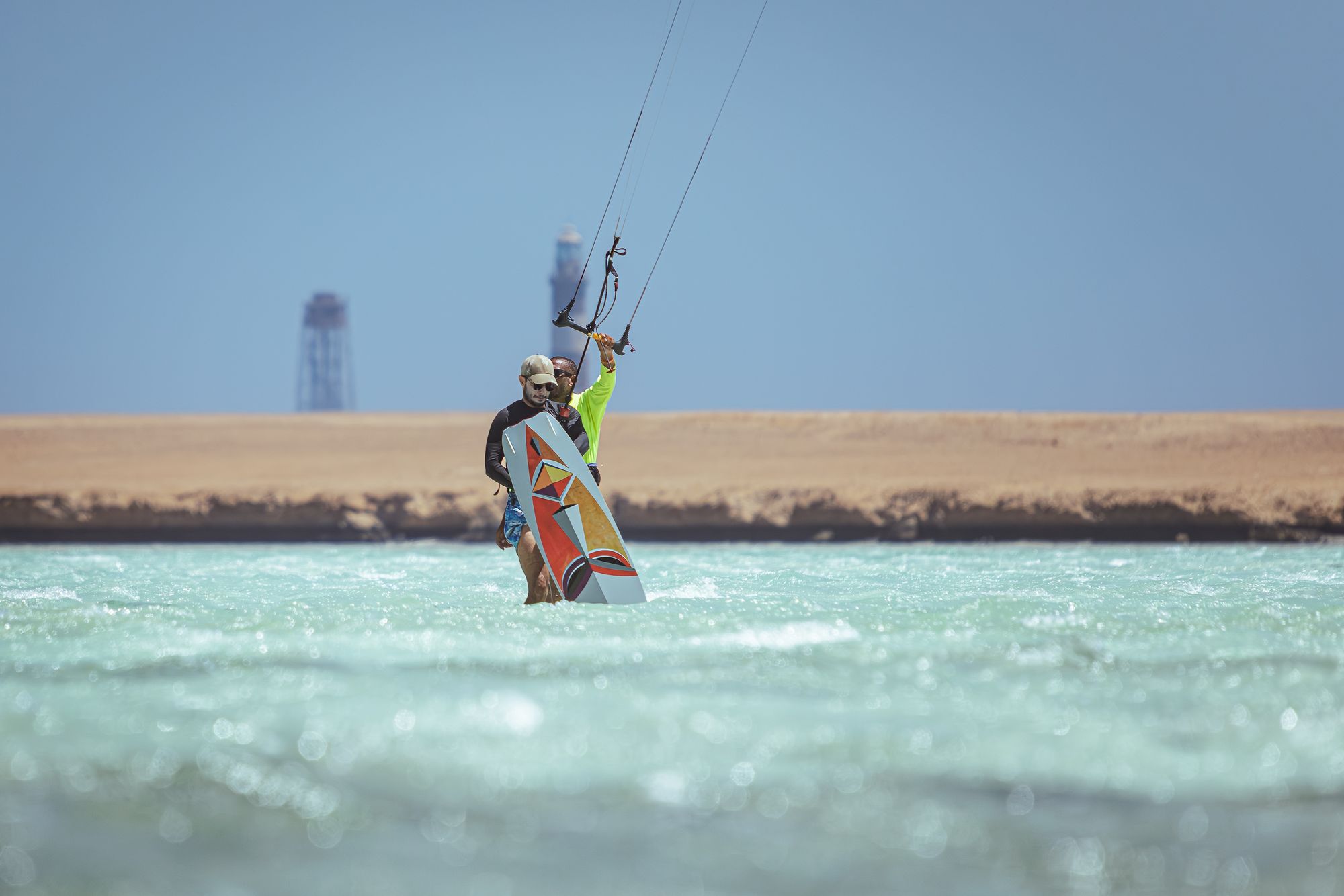 Kitesurfer riding across shallow turquoise water with the kite high above, on Egypt's Red Sea coast
