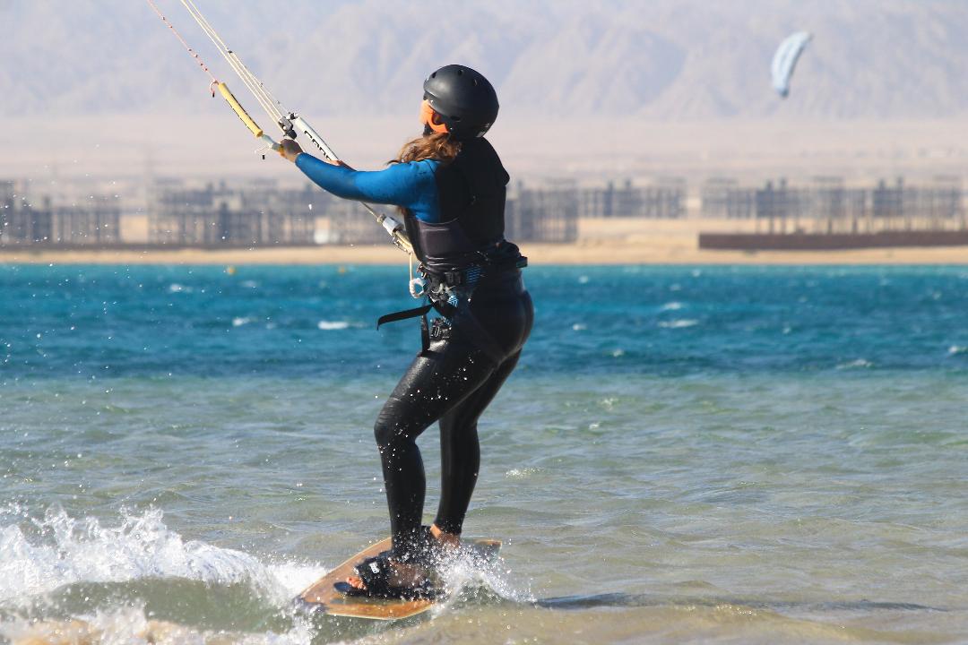 Kitesurfer riding a board along the coast