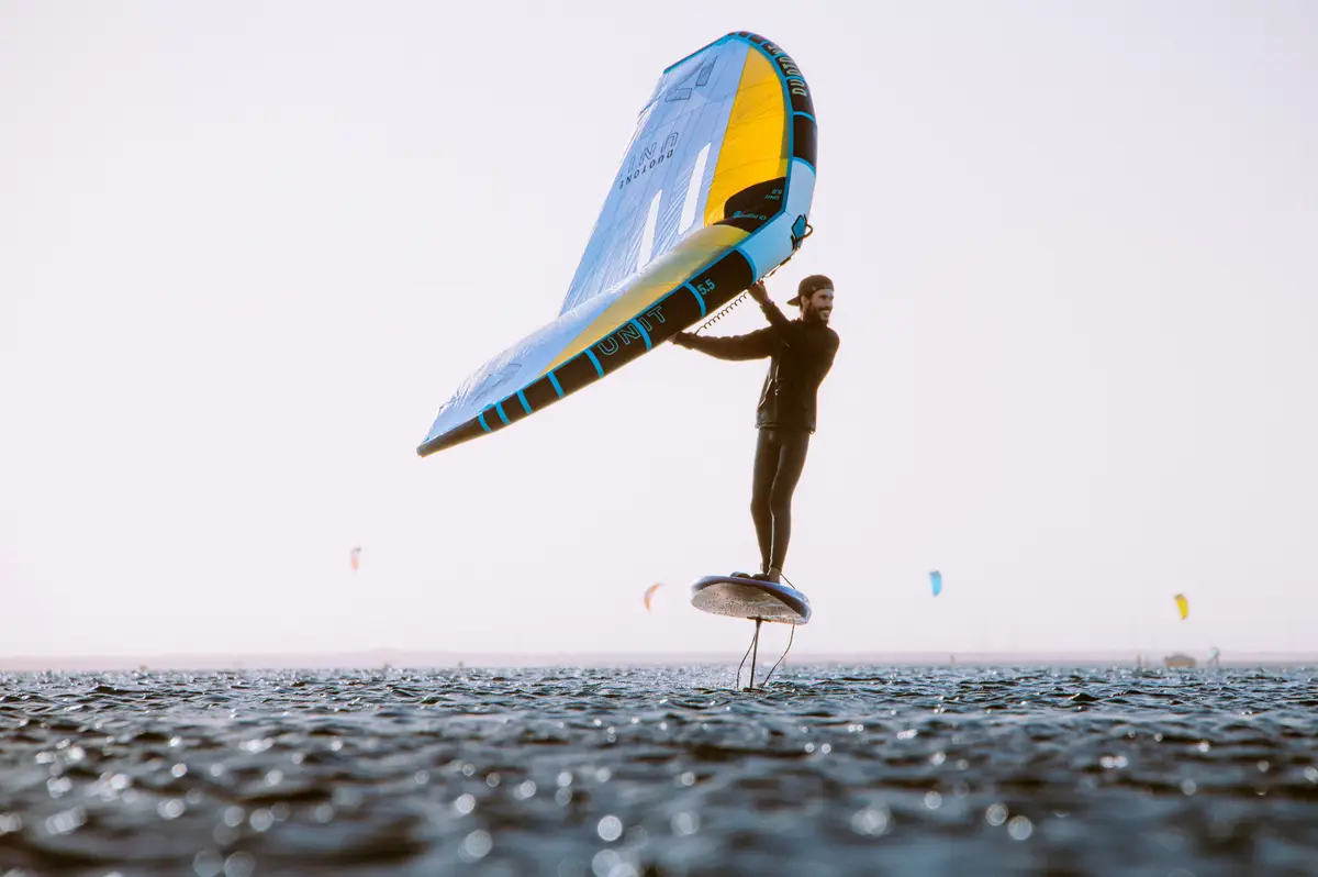A wing foiler flying above the water on the Dakhla lagoon