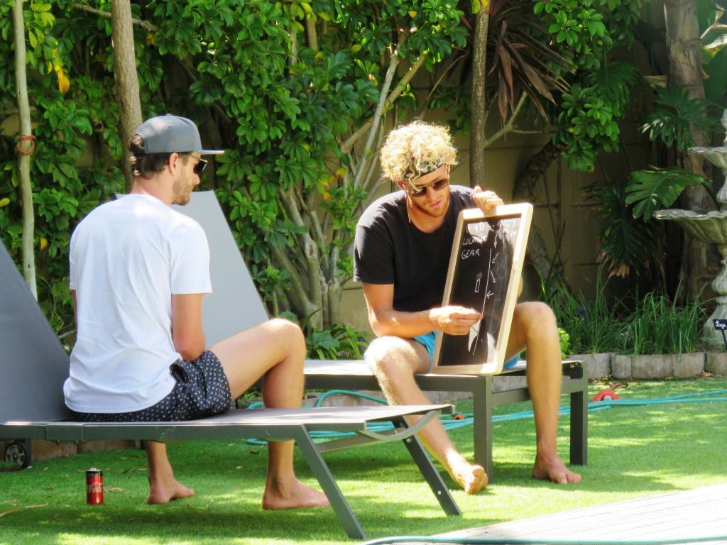 Two men relaxing on loungers in a green garden