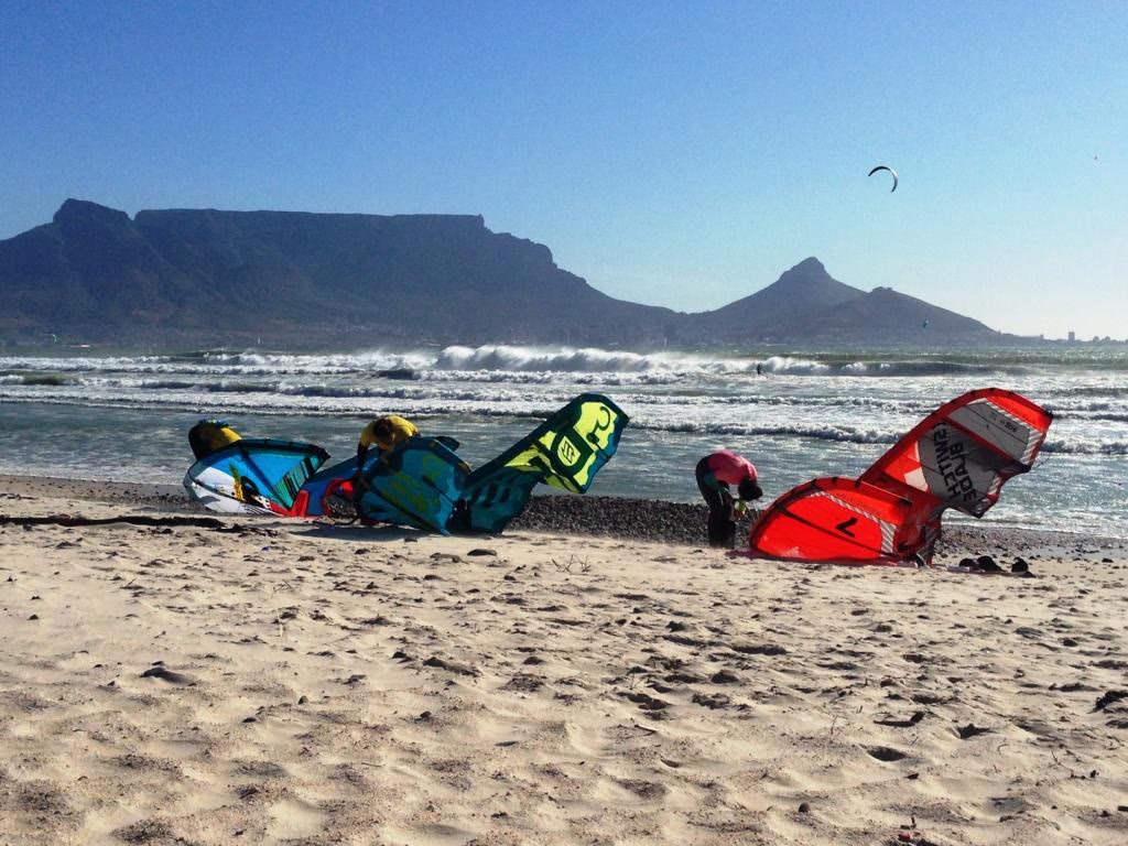 Colourful kites lying on the beach in front of Table Mountain