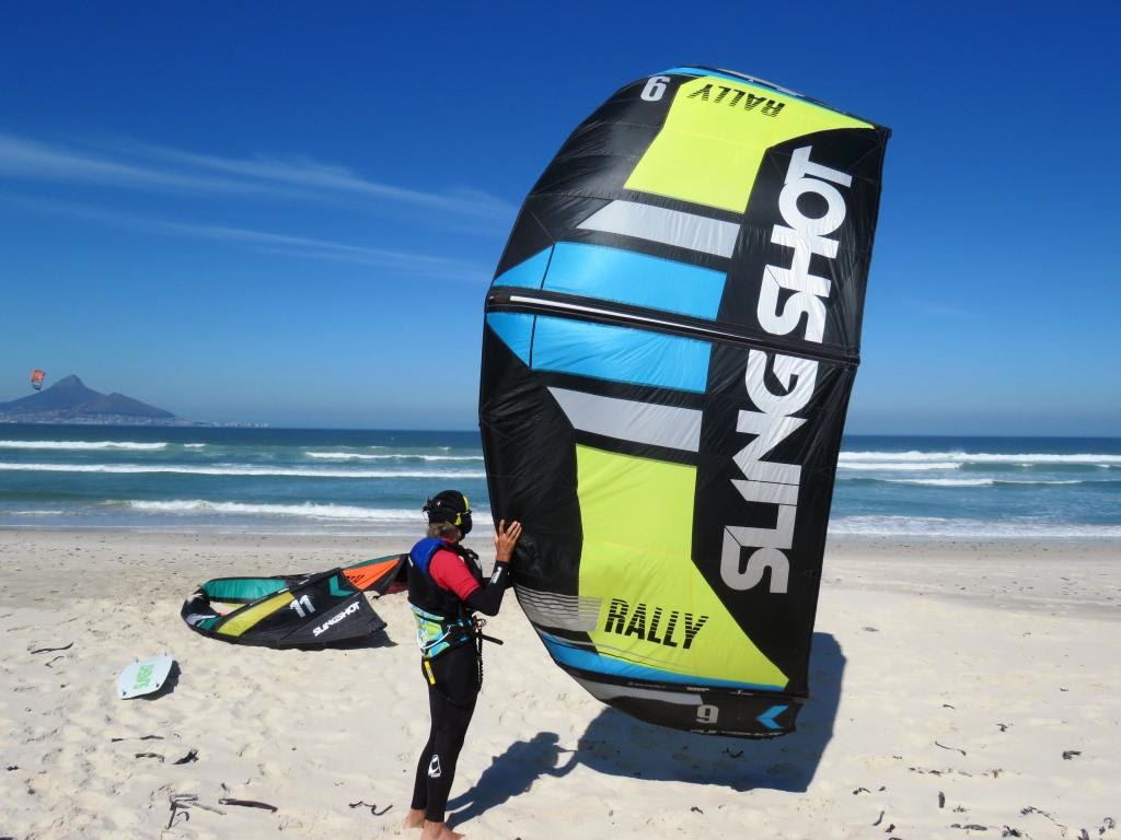 Rider holding a big yellow and blue kite on the beach