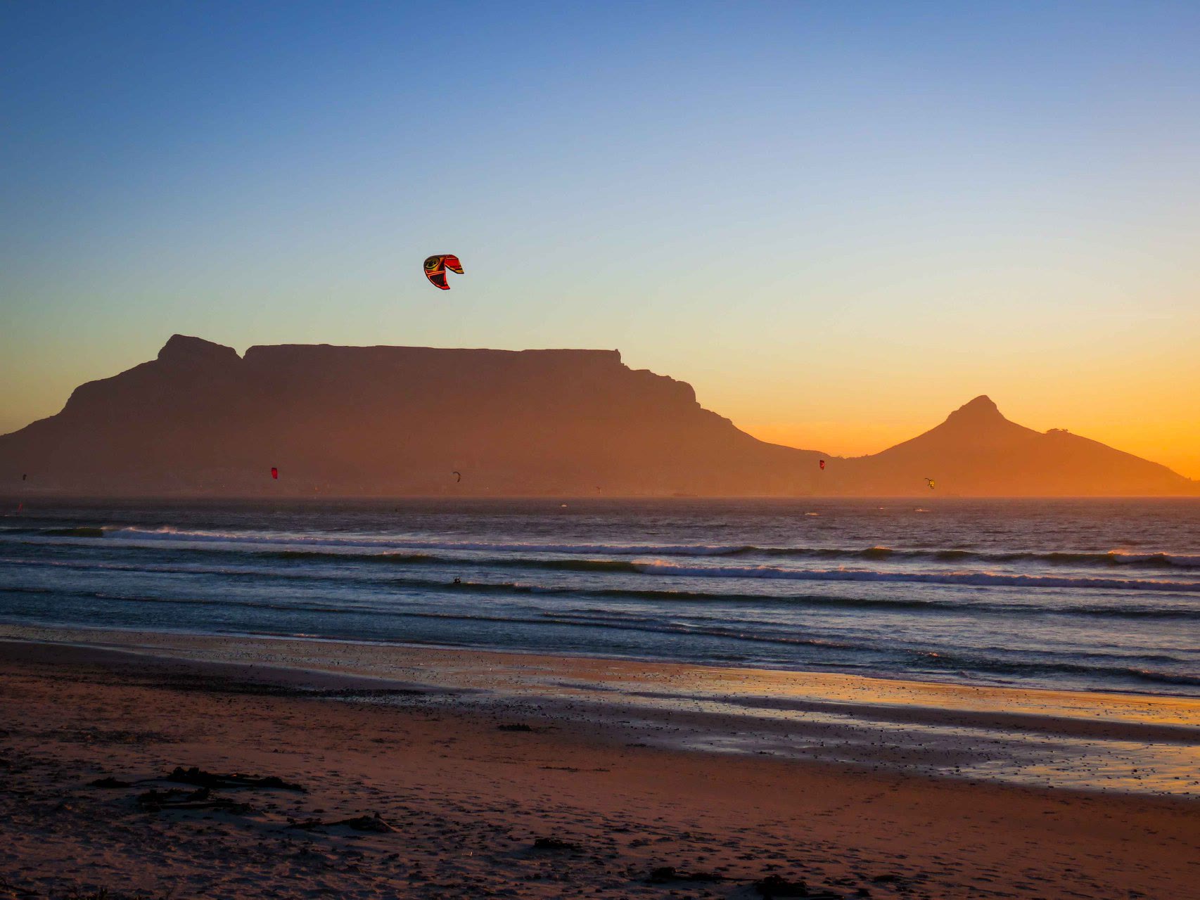 Kite in the evening sky over the beach with Table Mountain behind at sunset
