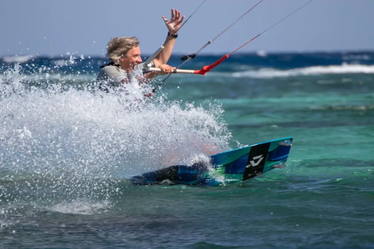 A kitesurfer carving through spray on Dahab Lagoon